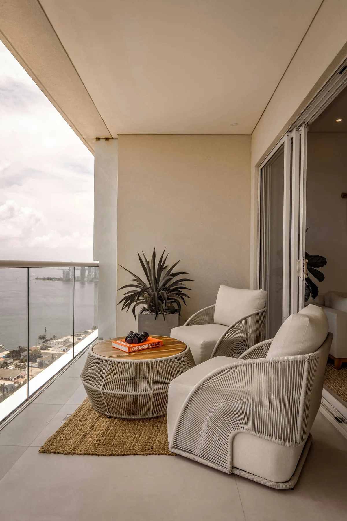 Balcony with two woven armchairs and a rattan side table