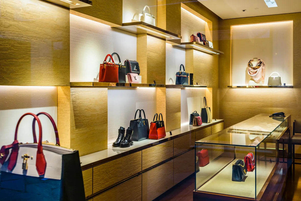 Handbag display with gold textured wall panels